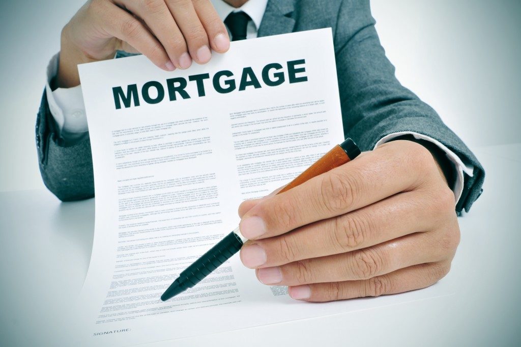 Man holding a mortgage contract and pen