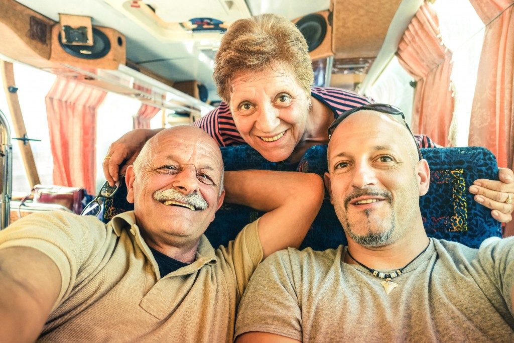 Man with his elderly parents in a tour bus