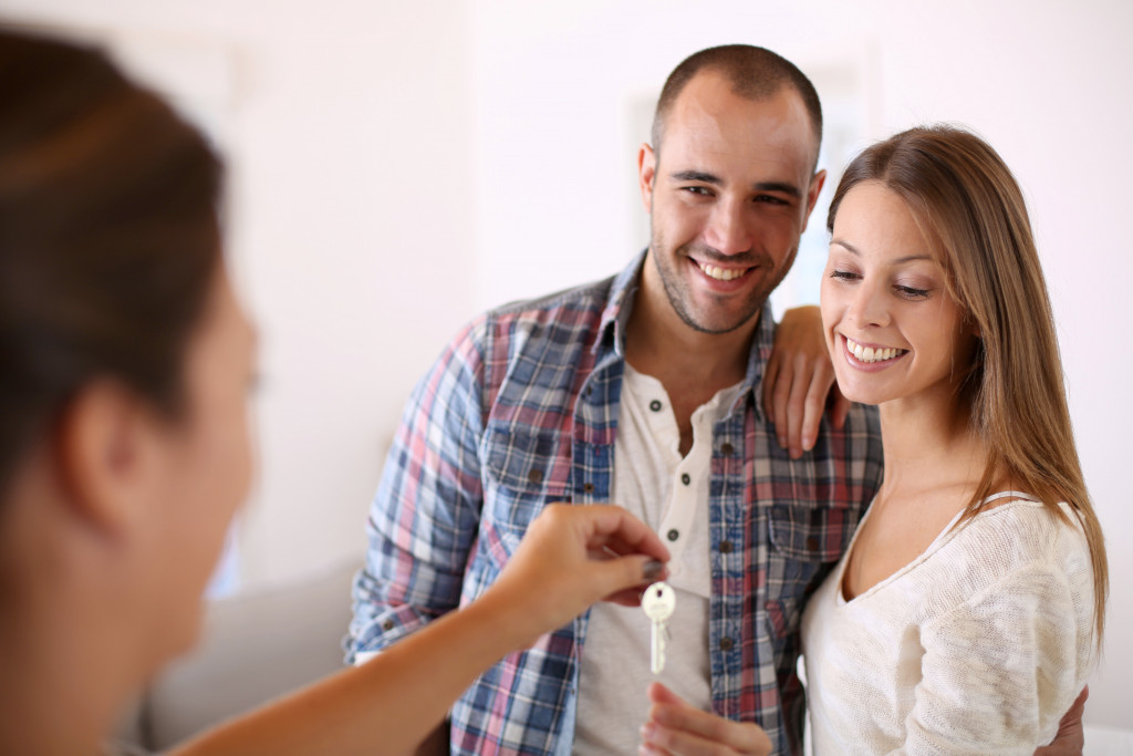 Cheerful couple getting keys of their new home