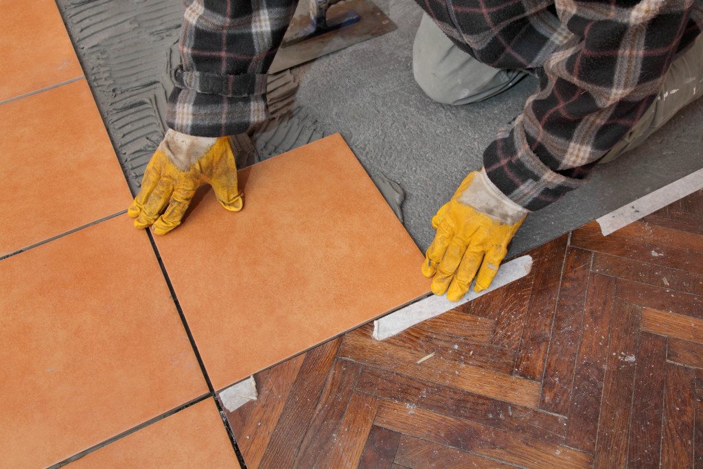 Professional laying tiles inside a house.