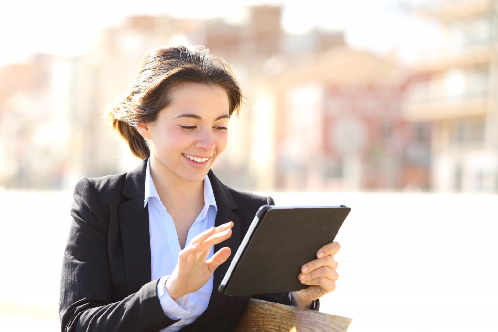 young entrepreneur woman checking tablet outdoors
